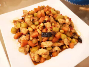 Eine Portion Sichuan Kung Pao Hühnchen auf einem Teller angerichtet
